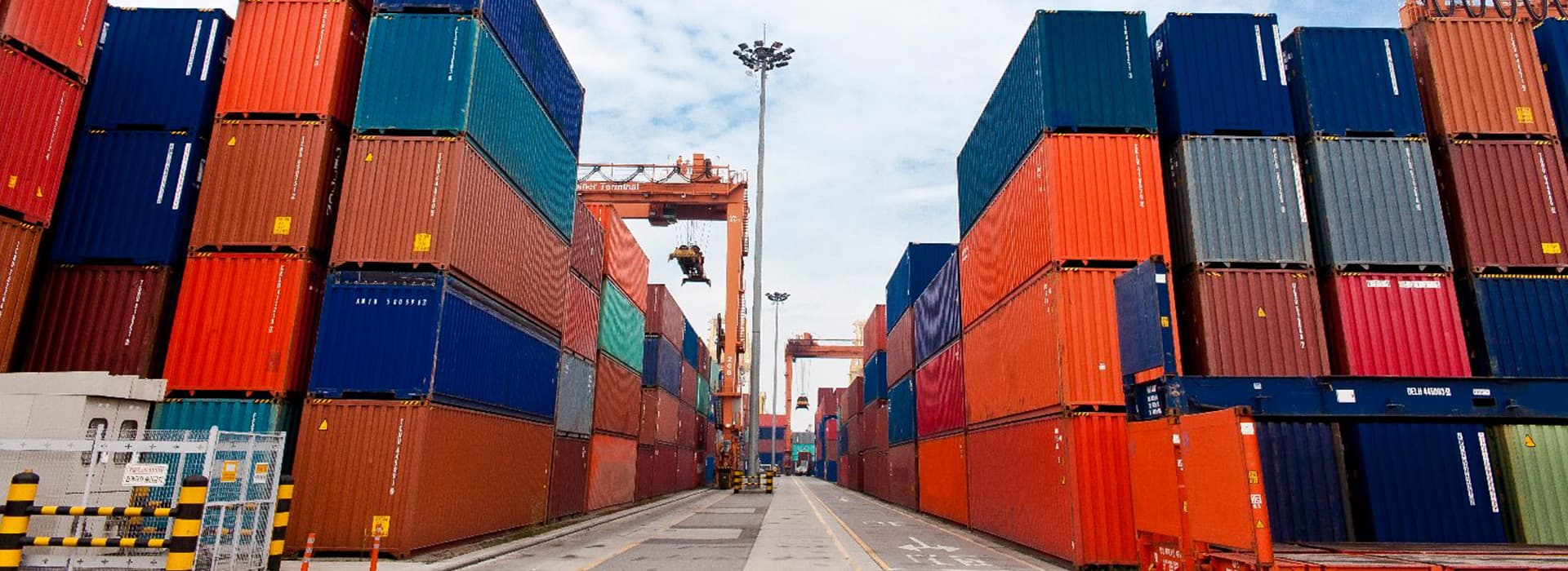 A corridor between stacked shipping containers